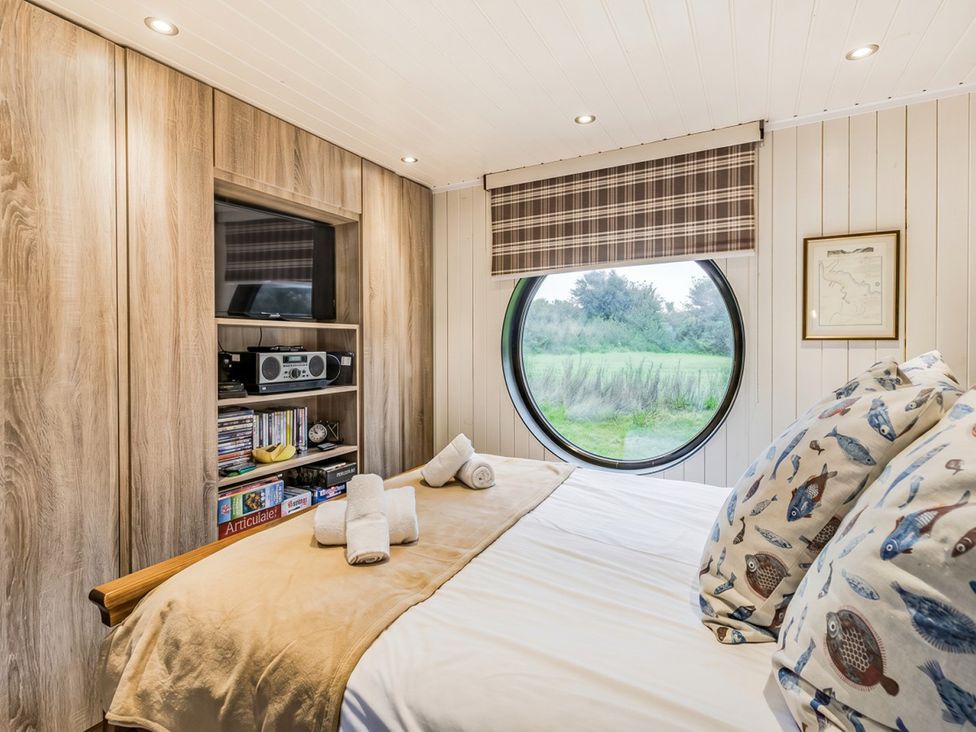 A bedroom with a round window and a bed at the property