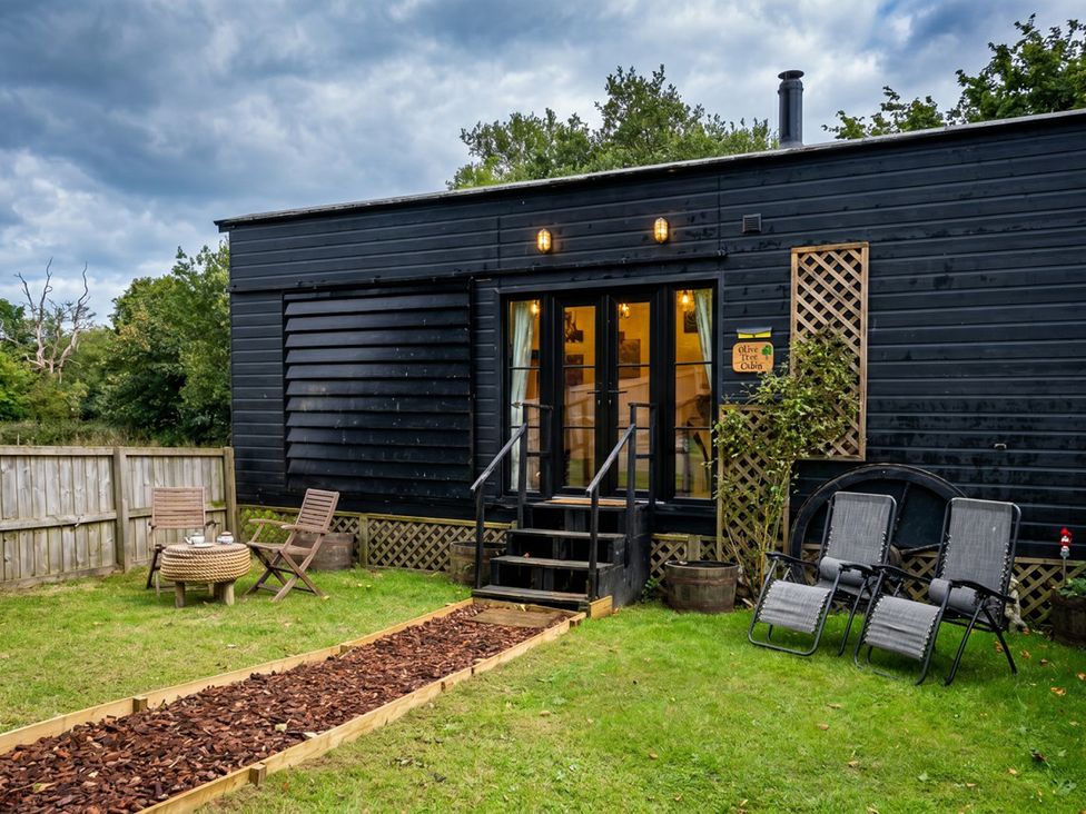 A house with garden furniture and a pathway in front of it at the cabin in a rural area