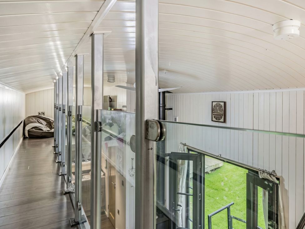 A loft area with a bean bag chair and glass railing overlooking a yard at the property