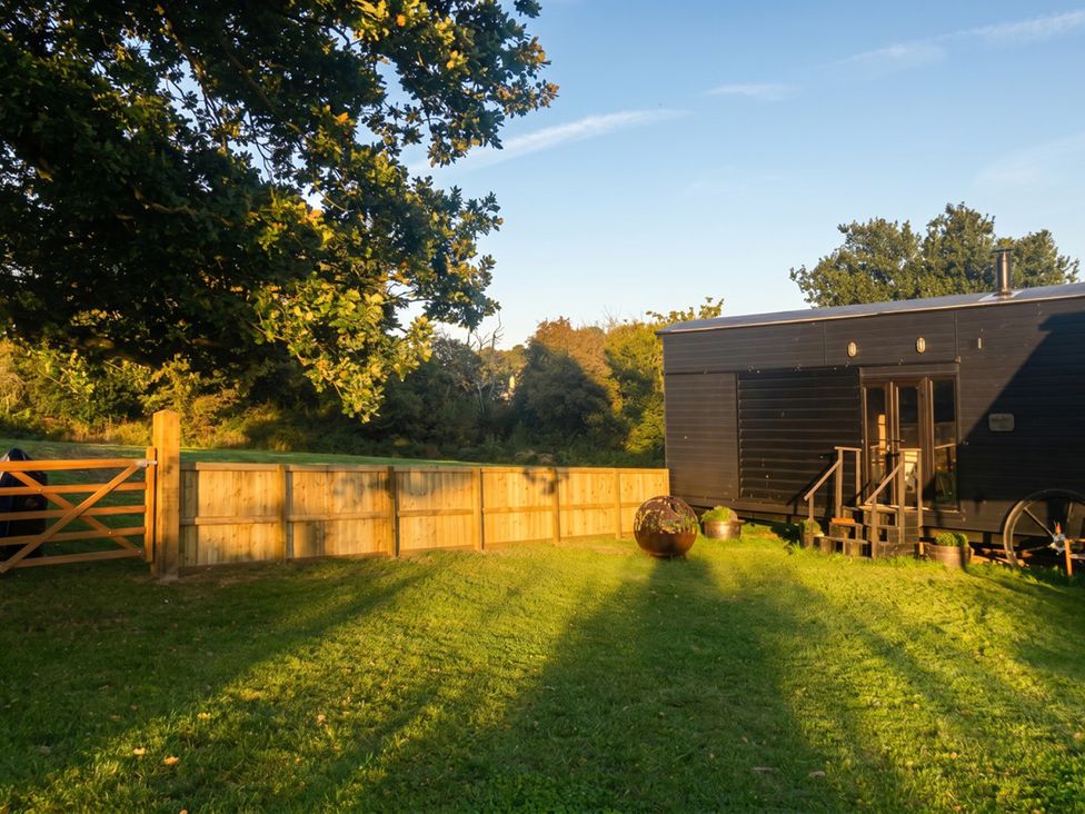 An outdoor area with a wooden gate and a black house at an unspecified location