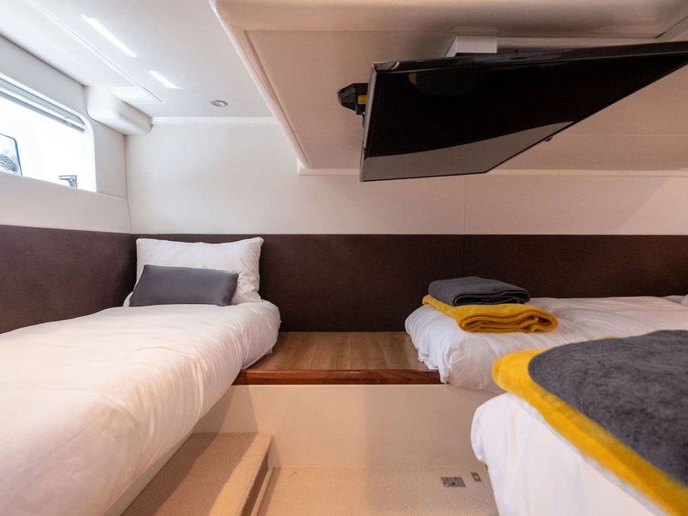 A bedroom with two beds and a television at a boat