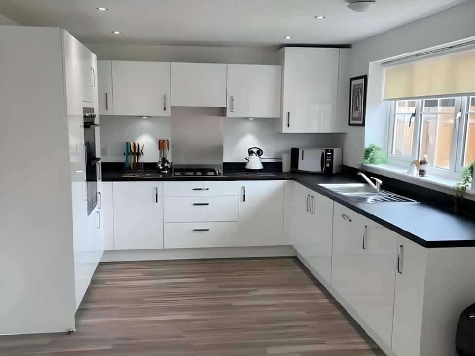 A kitchen with cabinets, stove, sink and microwave at the property