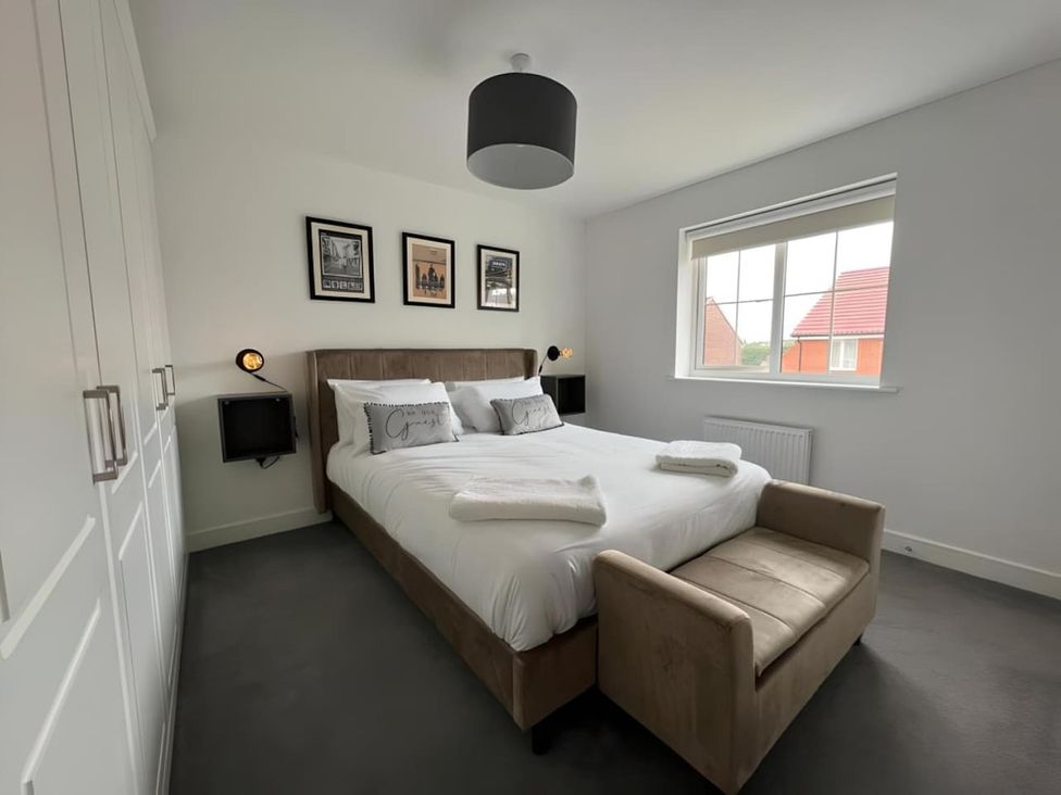 A bedroom with a bed and photographs on the wall at The Old Barn in Manchester