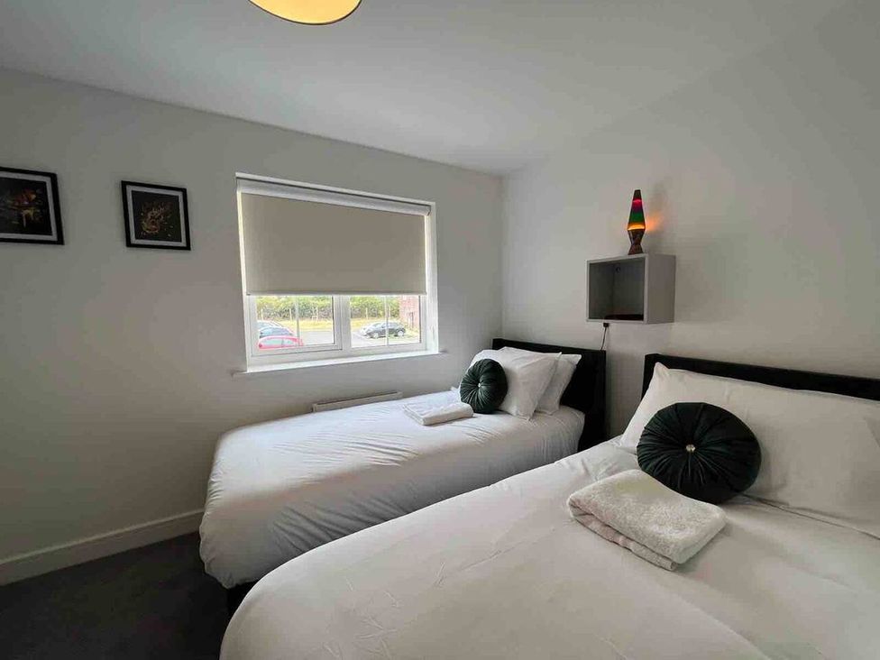A bedroom with two beds and a lamp at 