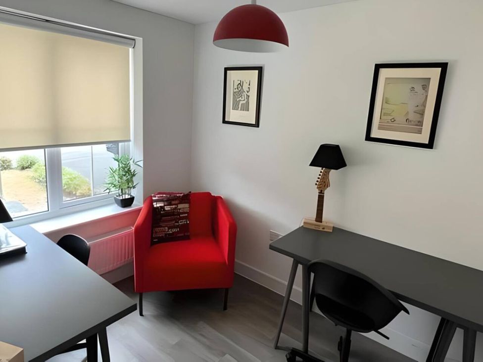 An office with a red armchair and a desk at the property