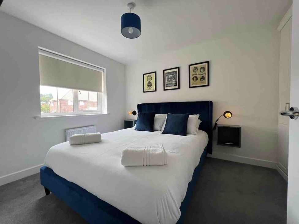 A bedroom with a bed, nightstand, and wall art at the property