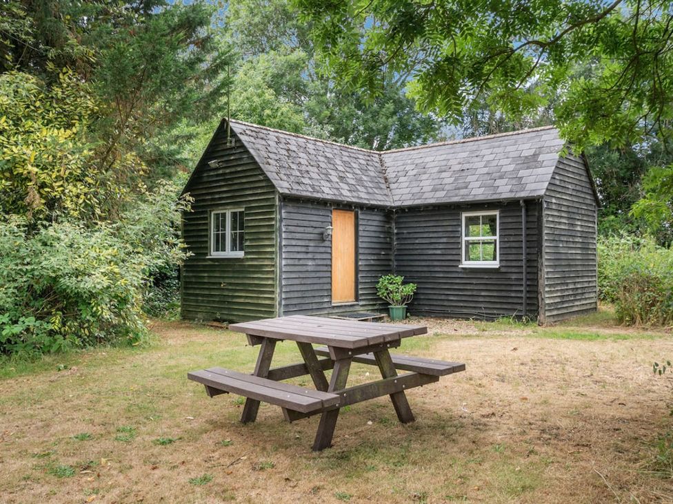 A cabin with a table and benches at The Hideaway in 