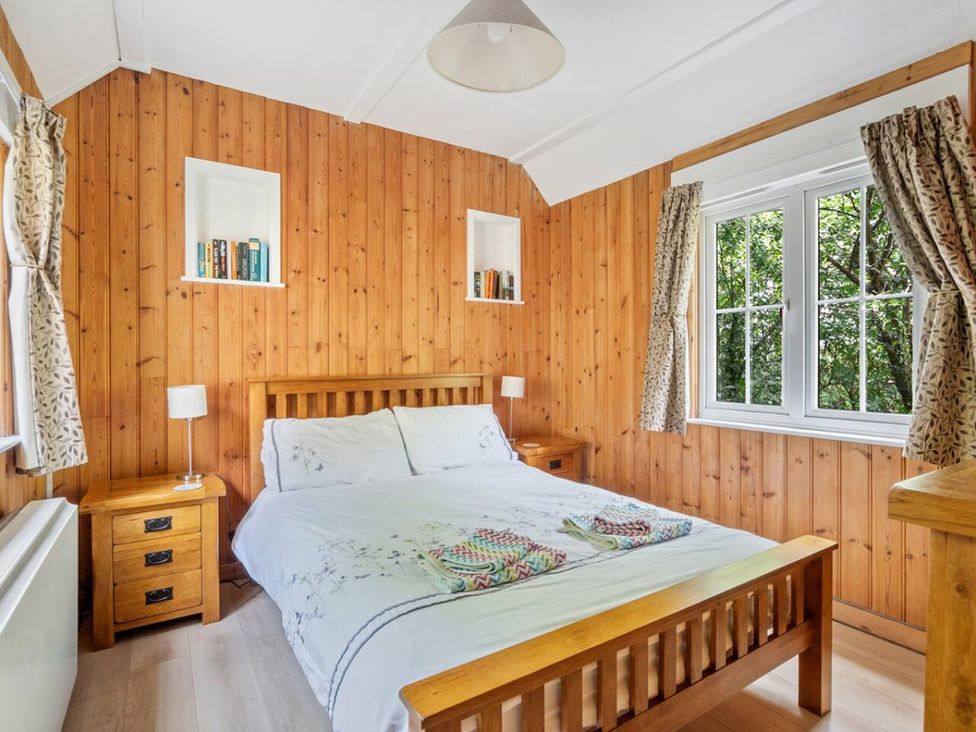 A bedroom with wood panel walls and a bed at The Hideaway in 