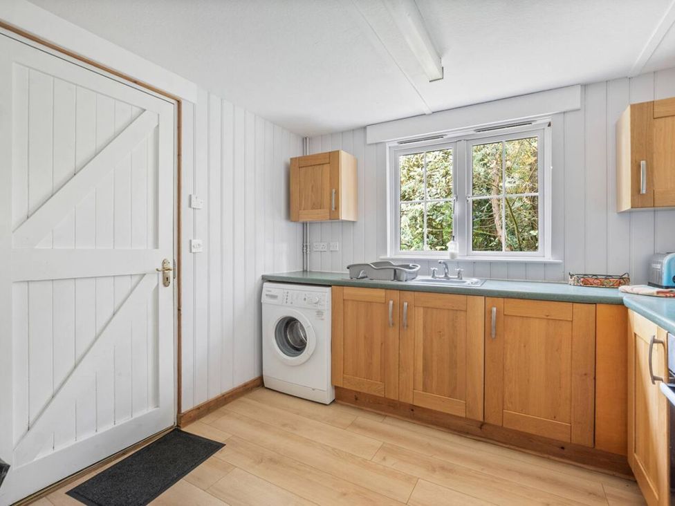 A kitchen with cabinets, a washing machine, and a sink at The Hideaway