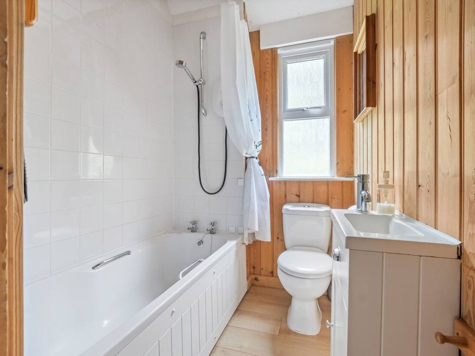 A bathroom with a bathtub, shower, toilet, and sink at The Hideaway
