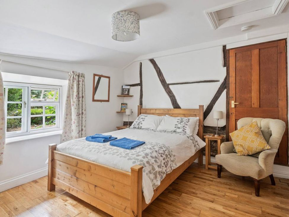 A bedroom with a wooden bed and window at The Old Post Office