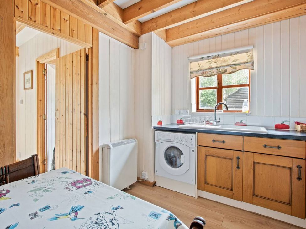 A kitchen with a washing machine and sink at Walnut Tree Cottage