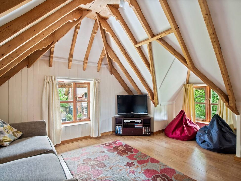 A living room with a sofa and television at Walnut Tree Cottage