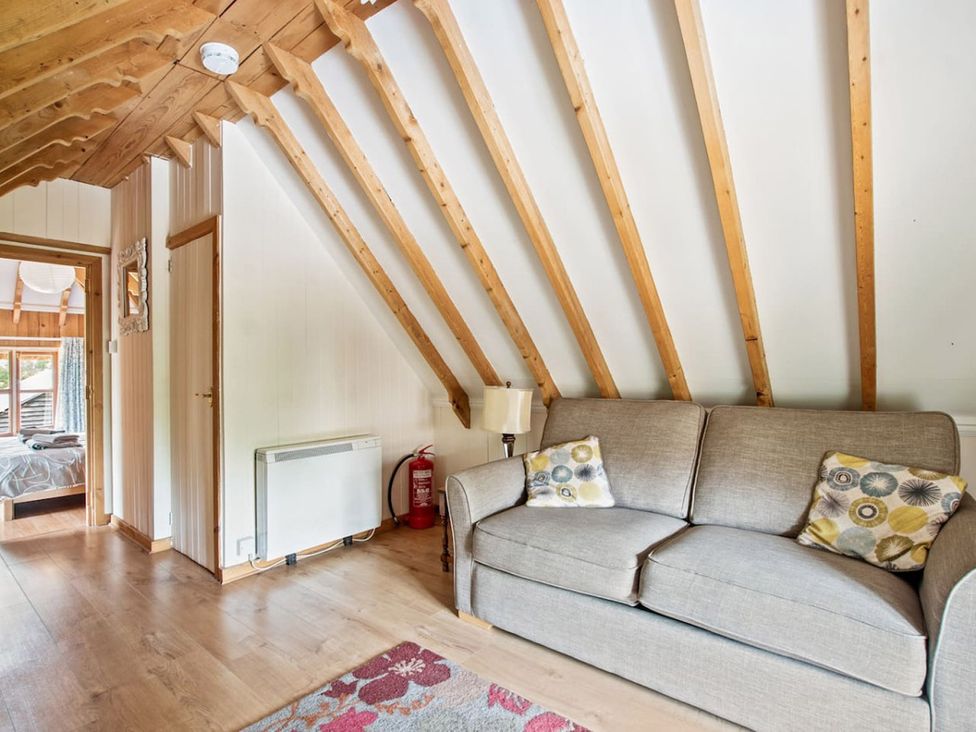 A living room with a sofa and a lamp at Walnut Tree Cottage