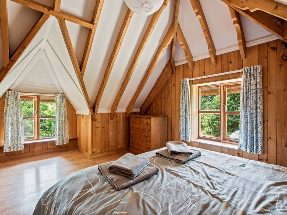 A bedroom with a bed and dresser at Walnut Tree Cottage