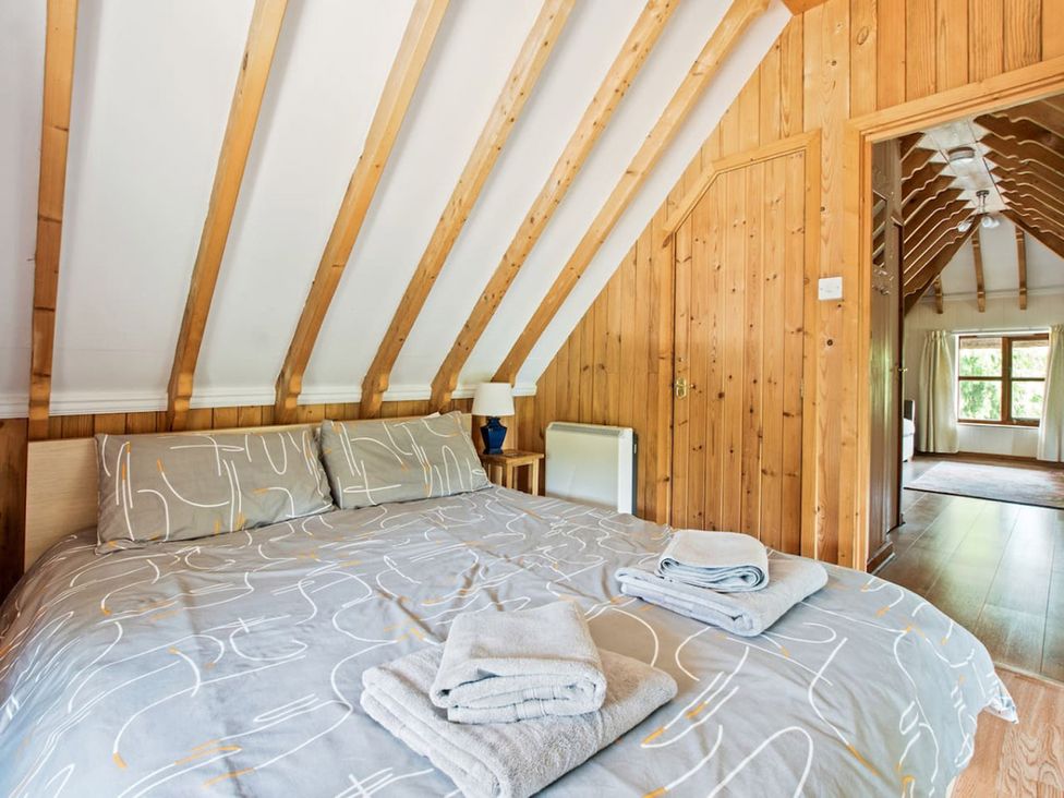 A bedroom with a bed and towels on it at Walnut Tree Cottage