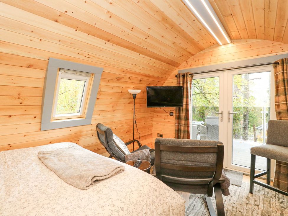 A bedroom with a bed and a television at Elleric Pods - The Last Resort in Appin