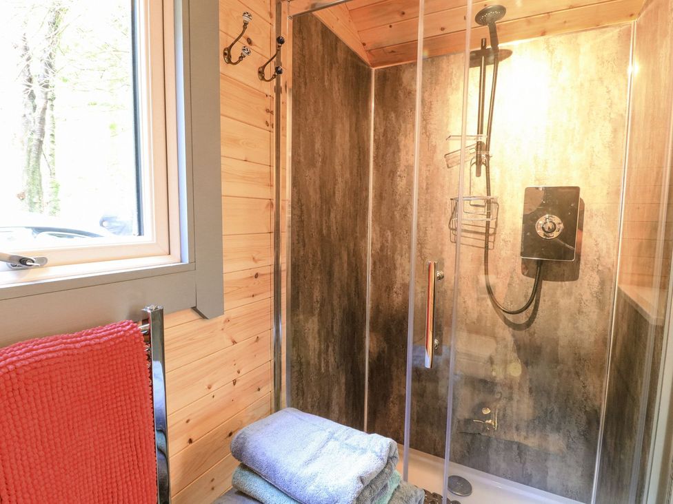 A bathroom with a shower and towels at Elleric Pods - The Last Resort Appin