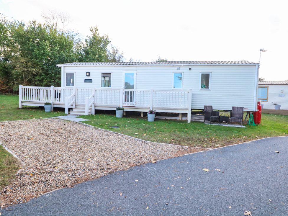 A mobile home with a deck and outdoor furniture at Four Seasons in Great Yarmouth