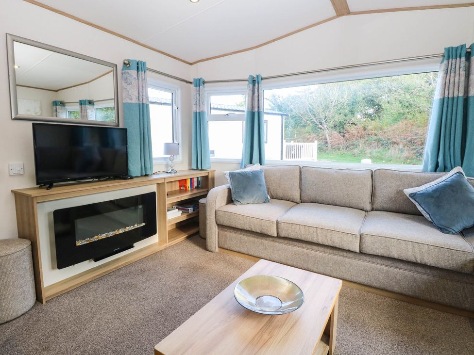 A living room with a sofa and television at Four Seasons in Great Yarmouth