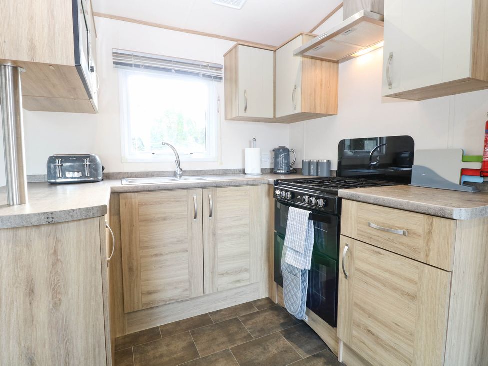 A kitchen with a gas stove and sink at Four Seasons in Great Yarmouth