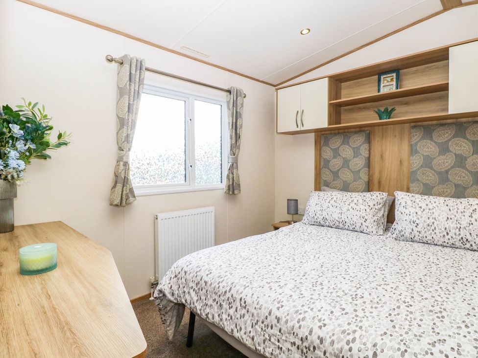 A bedroom with a bed and window at Four Seasons in Great Yarmouth