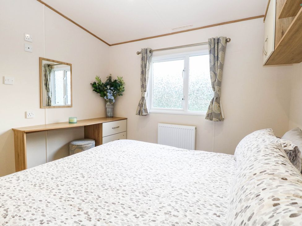 A bedroom with a bed and a dresser at Four Seasons in Great Yarmouth