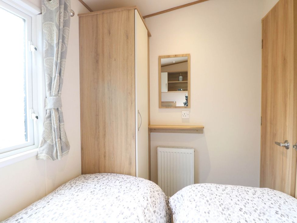 A bedroom with a wardrobe and a mirror at Four Seasons Great Yarmouth