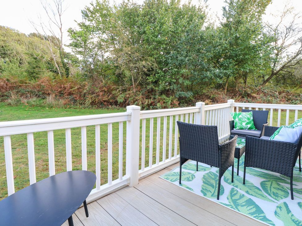 An outdoor area with chairs and a table on a deck at Four Seasons in Great Yarmouth