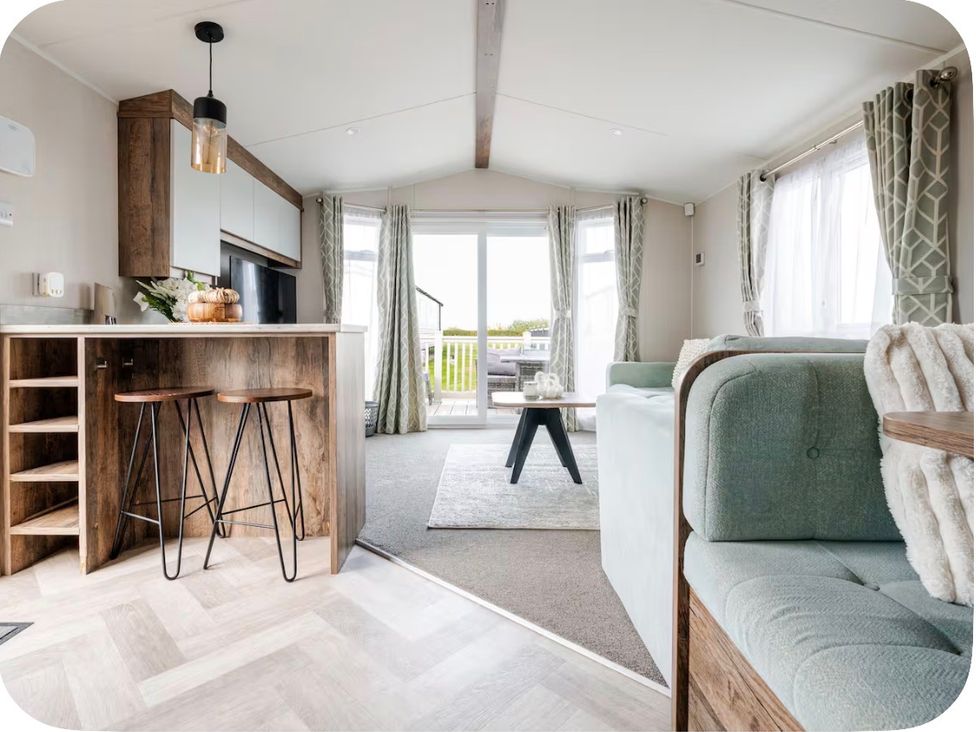 A living room with a kitchen island and bar stools at Brookwood Willerby, 36 bay view in Filey