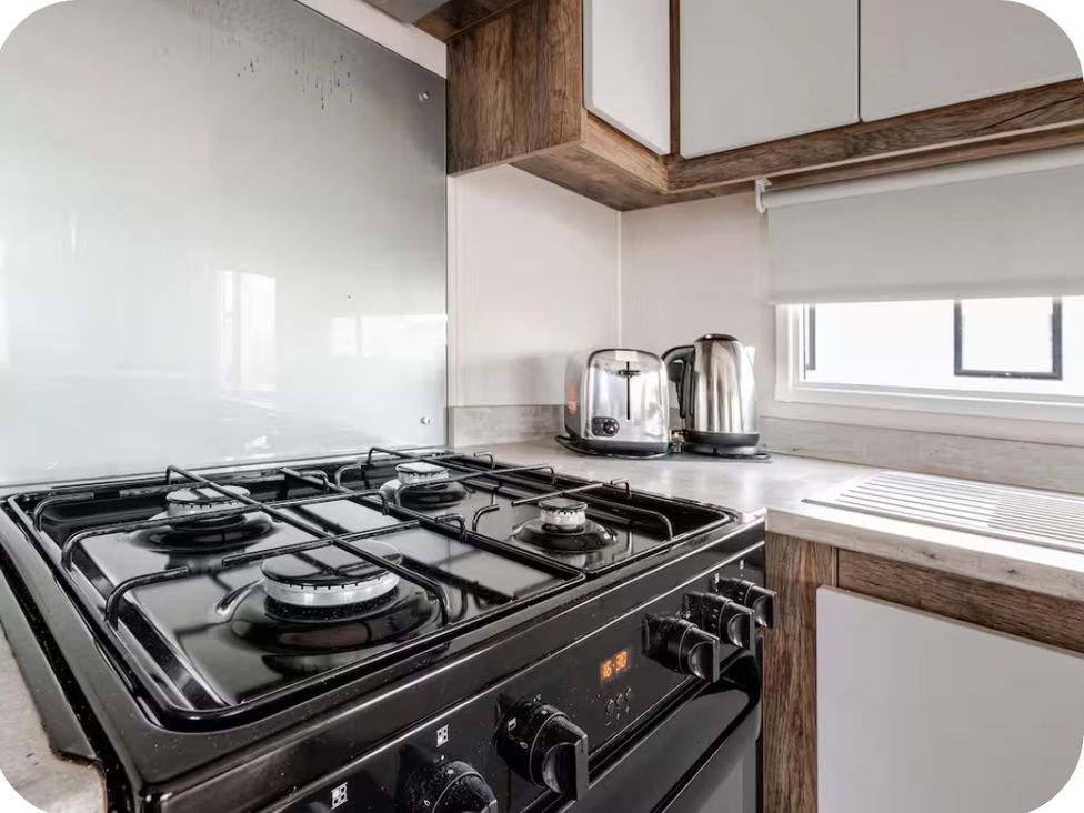 A kitchen with gas stove and appliances at Brookwood Willerby, 36 bay view, Filey