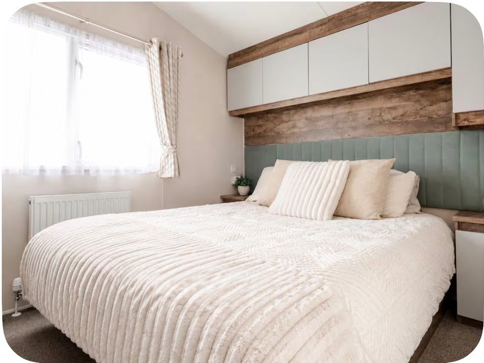 A bedroom with a large bed and shelves at Brookwood Willerby, 36 bay view, Filey