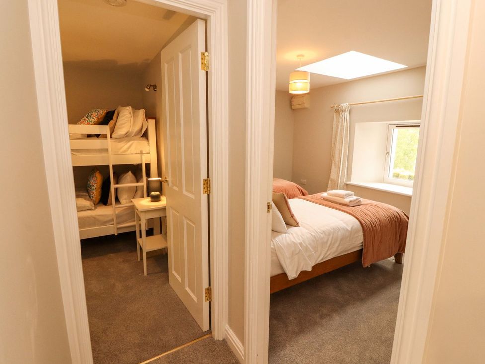 A bedroom with bunk bed and double bed at Swallow's Nest in Keswick