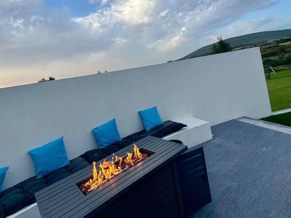 An outdoor seating area with a fire pit and cushions at Jeannies retreat at little lake fb
