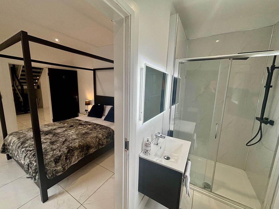 A bedroom with a bed and a bathroom with a sink and shower at Jeannies retreat at little lake fb