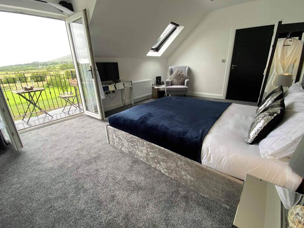 A bedroom with a bed and a balcony at Jeannies retreat at little lake fb