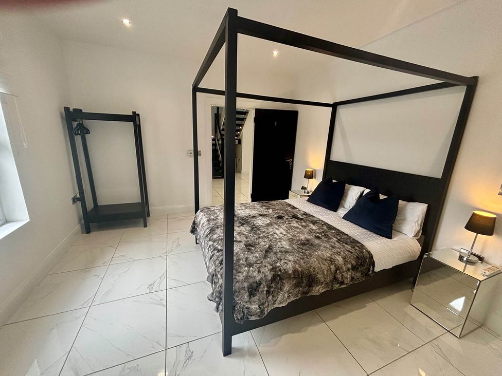 A bedroom with a four-poster bed and a wardrobe at Jeannies retreat at little lake fb