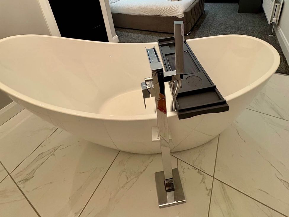 A bathtub with a faucet and a bath tray at Jeannies retreat at little lake fb