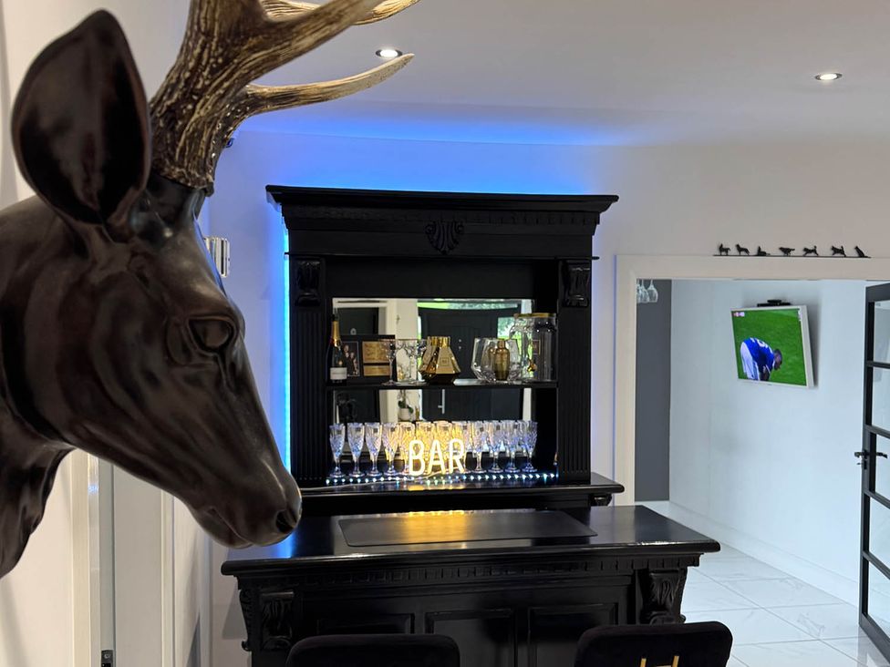 A bar with stools and a decorative deer head at Jeannies retreat at little lake fb