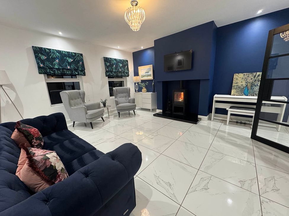 A living room with a sofa, two armchairs, and a fireplace at Jeannies retreat at little lake fb