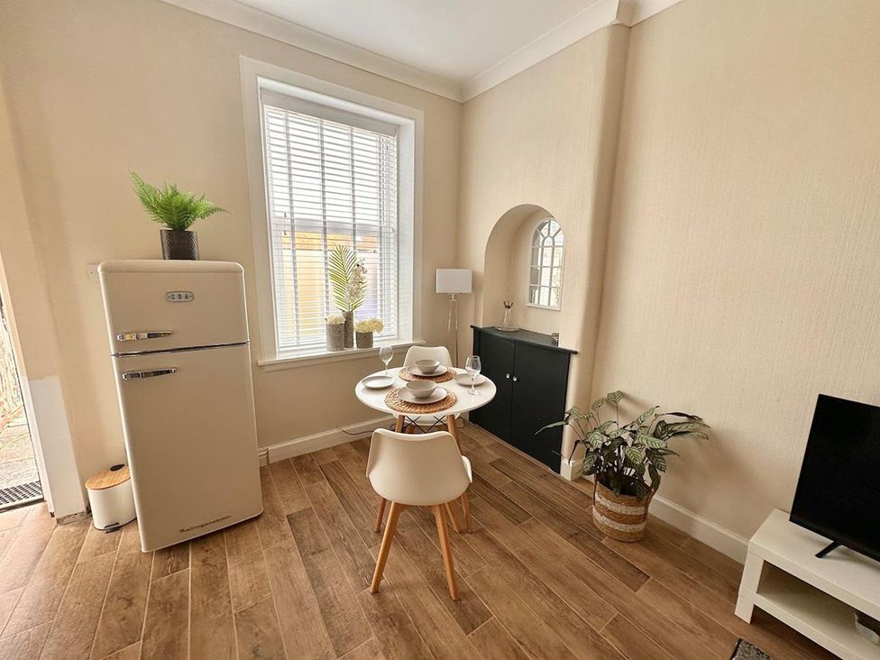 A kitchen with a table and chairs in front of a window at The Old Barn in Manchester