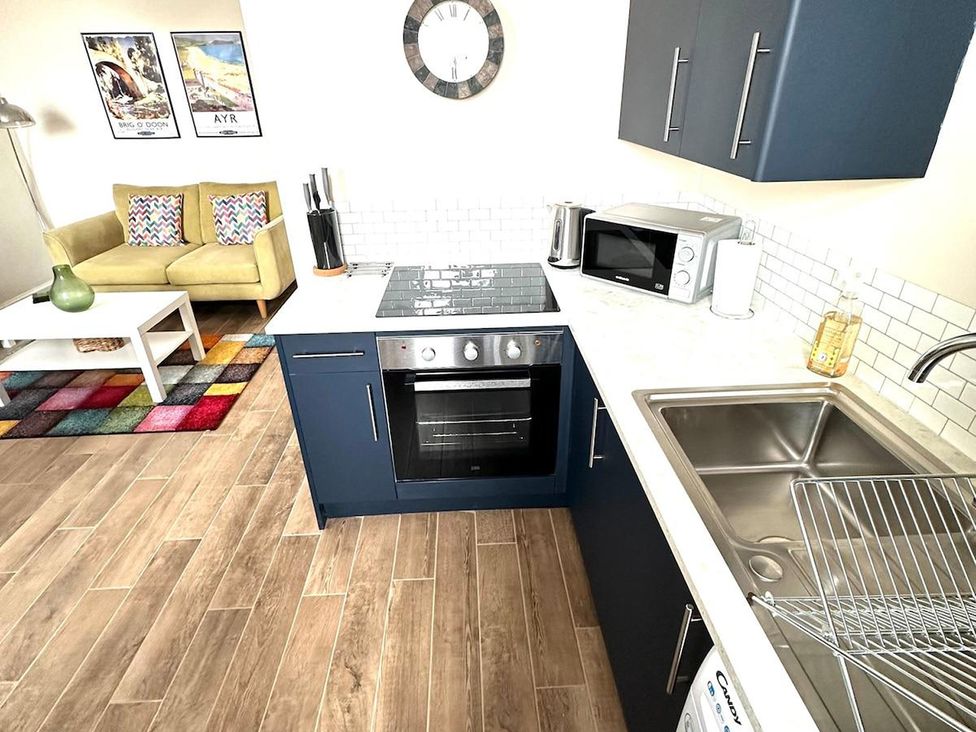 A kitchen with counter, oven, microwave and sink at an unknown property