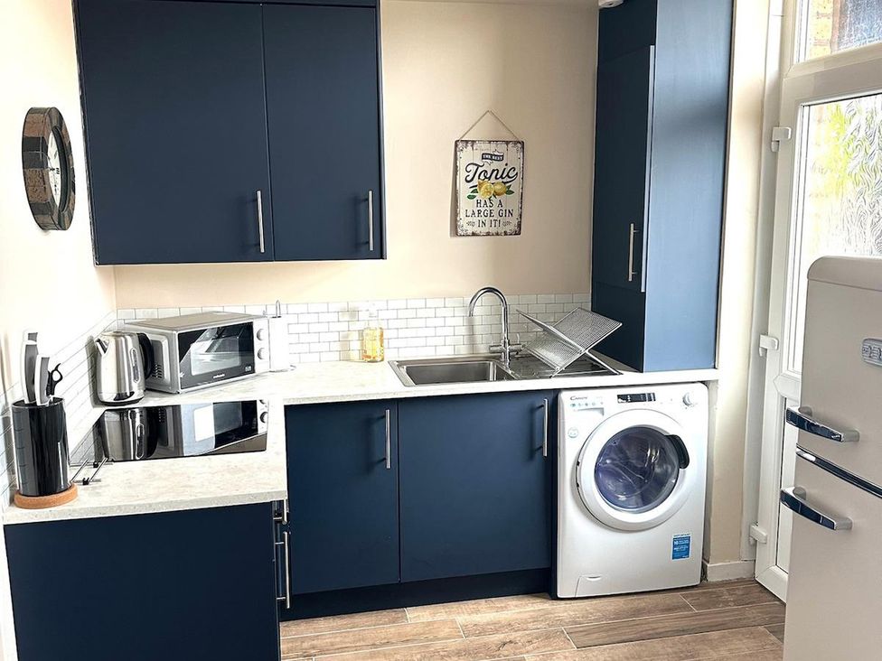 A kitchen with dark cabinets and appliances at The Old Barn in Manchester