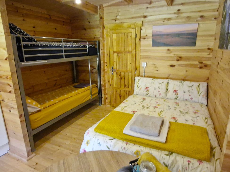 A bedroom with a bunk bed and a double bed at Snowdrop Lodge Dog friendly Nr Anderby Creek Alford