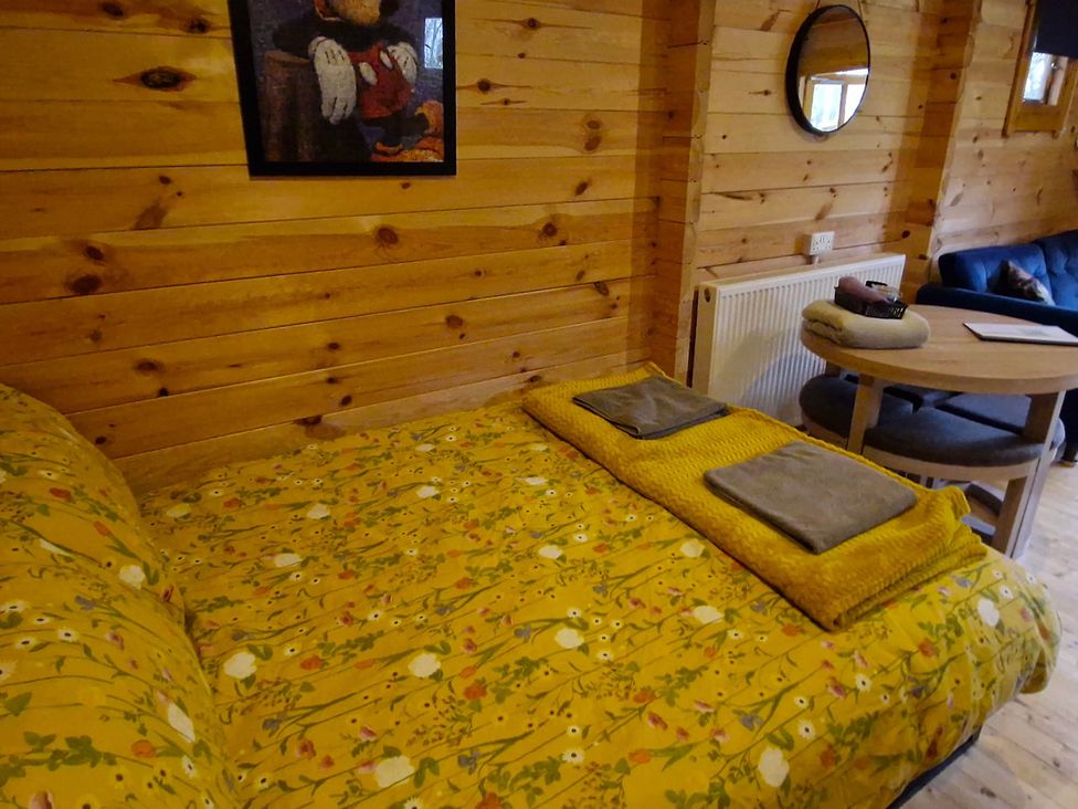 A bedroom with a bed and table at Snowdrop Lodge Dog friendly Nr Anderby Creek in Alford