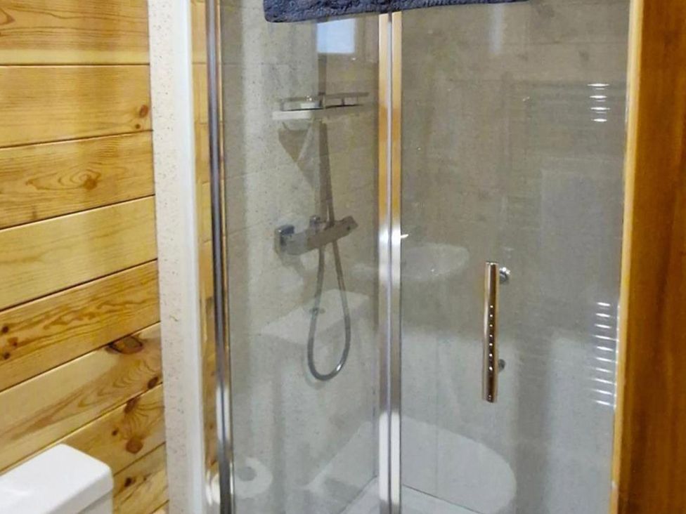 A shower and toilet in a bathroom at Snowdrop Lodge Dog friendly Nr Anderby Creek in Alford