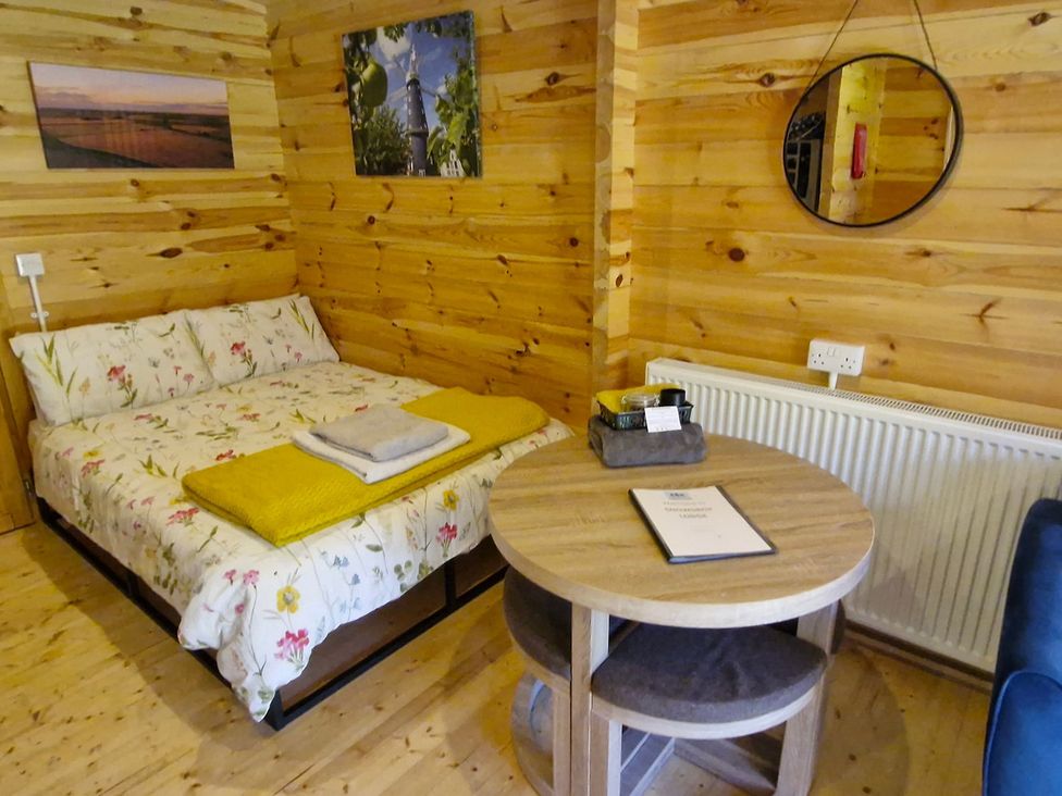 A bedroom with a bed and a table at Snowdrop Lodge Dog friendly Nr Anderby Creek, Alford