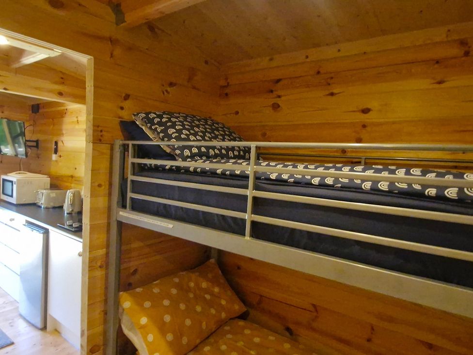 A bedroom with bunk bed and kitchenette at Snowdrop Lodge Dog friendly Nr Anderby Creek in Alford