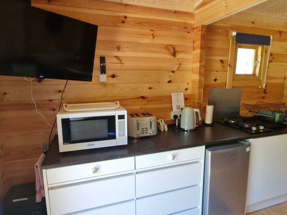 A kitchen with appliances and a window at Snowdrop Lodge Dog friendly Nr Anderby Creek in Alford