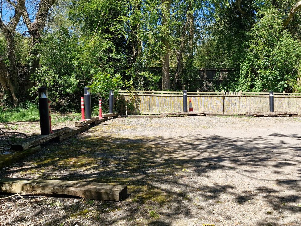 An outdoor parking area with trees and a fence at Snowdrop Lodge Dog friendly Nr Anderby Creek Alford